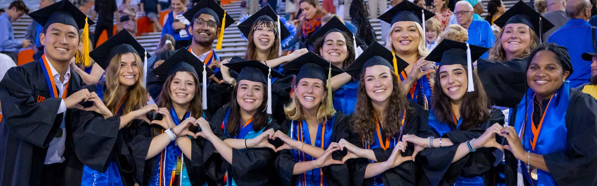 Graduating students forming hearts with their hands