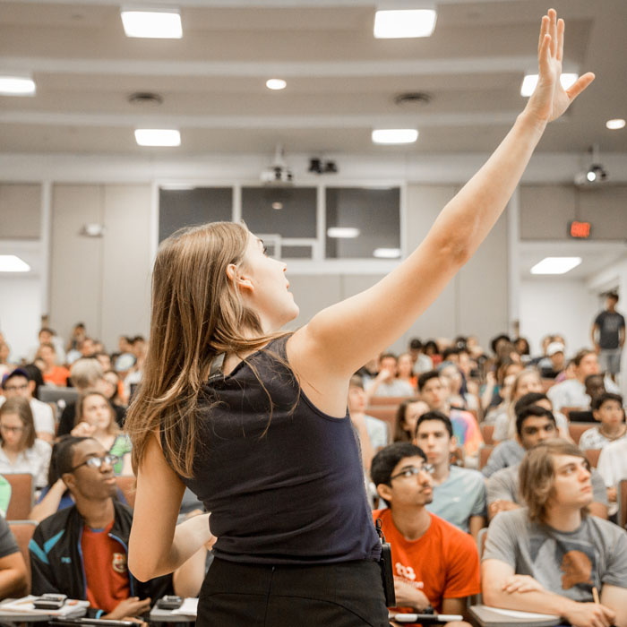 woman teaching a class with her arm in the air