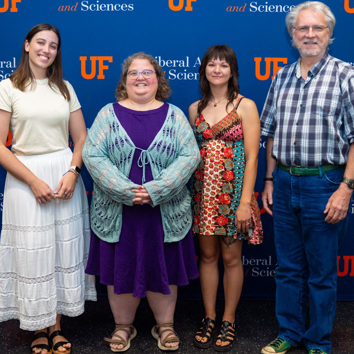 four people in front of a backdrop for CLAS