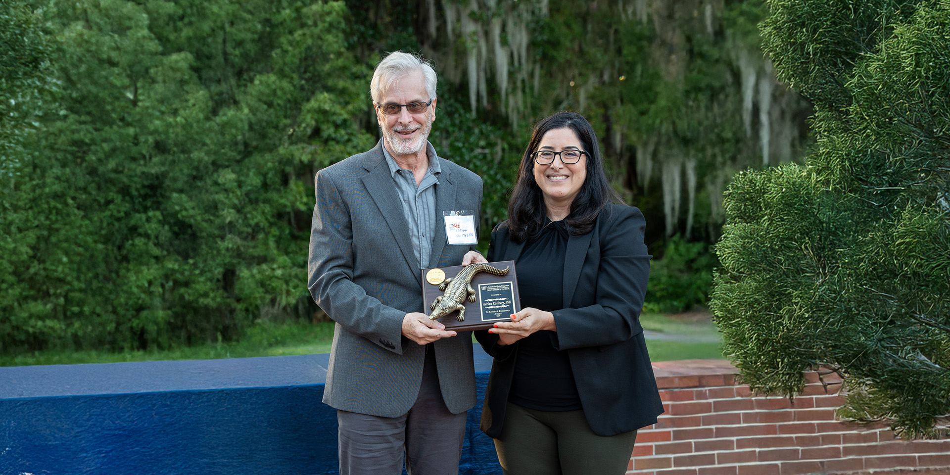 man and woman holding a plaque